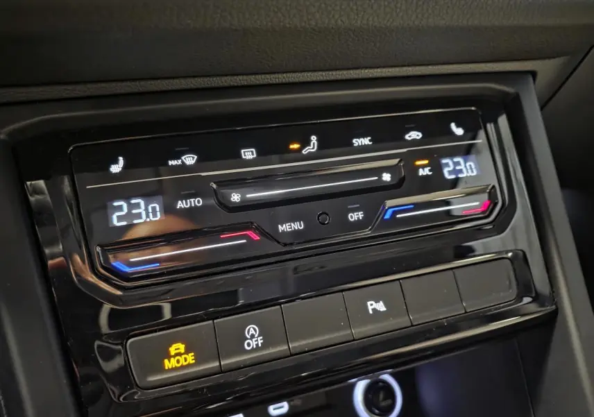 Détail du tableau de bord du Volkswagen Touran 2024 montrant la climatisation automatique à 23°C et commandes tactiles.