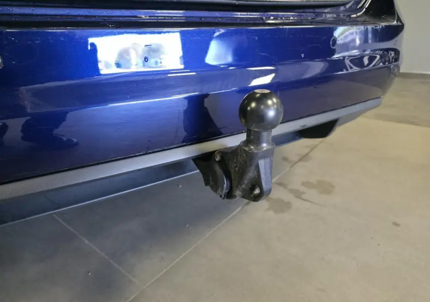 Gros plan sur le crochet d'attelage escamotable arrière d'un Volkswagen Touran bleu 2024.