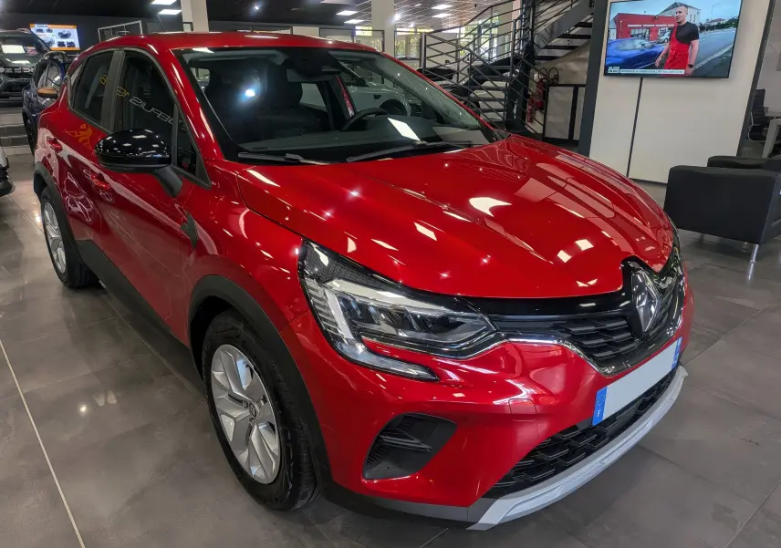 Renault Captur TCe 90 CH ZEN rouge Flamme en 3/4 avant droit, avec phares LED et jantes alliage visibles en showroom.