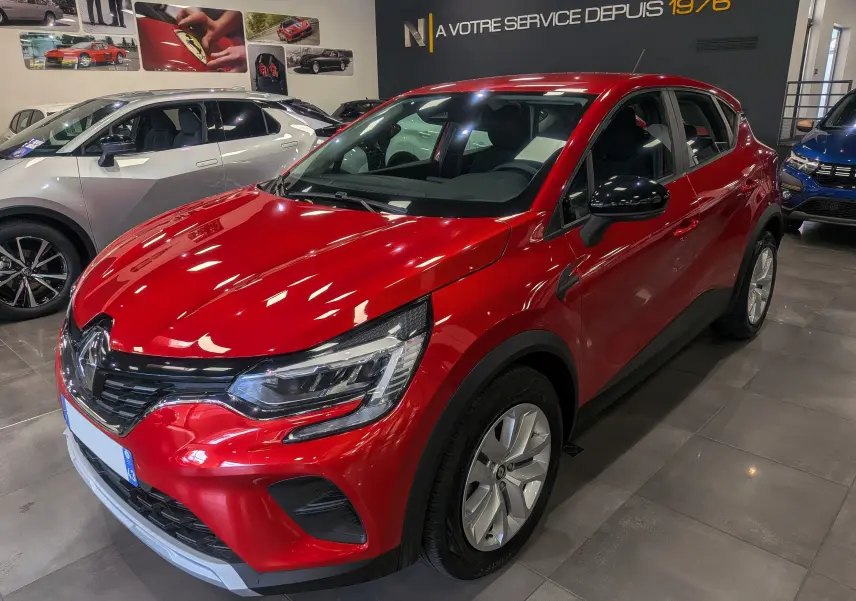 Renault Captur TCe 90 CH Zen rouge flamme en 3/4 avant droit, avec jantes argentées et rétroviseurs noirs.