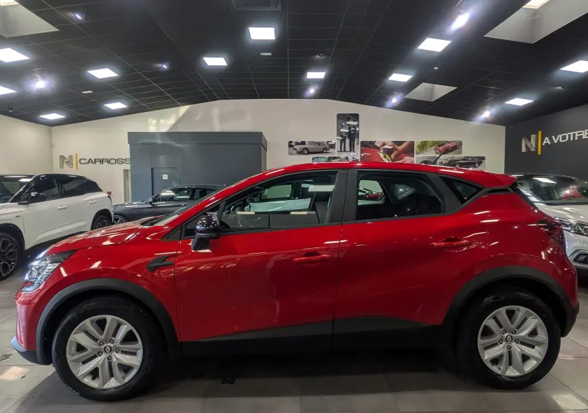 Profil latéral gauche du Renault Captur TCe 90 CH ZEN 2023 en Rouge Flamme, avec jantes alliage et rétroviseurs noirs.