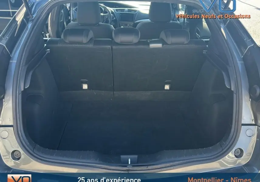 Coffre ouvert d'une Honda Civic gris 2015, vue arrière montrant l'espace de chargement et les sièges arrière.