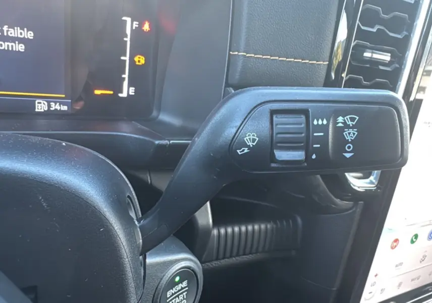 Gros plan sur la commande d’essuie-glace noire à gauche du volant dans l’habitacle du Ford Ranger gris carbone 2025.