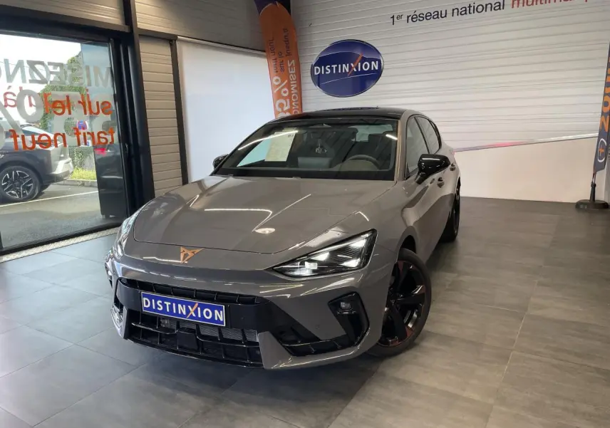 Vue 3/4 avant de la CUPRA Leon 2.0 TDI gris Graphène avec jantes cuivrées et logo CUPRA sur le capot.