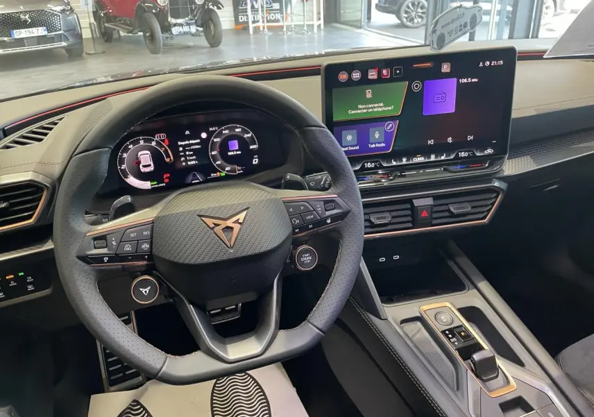 Vue intérieure du poste de conduite du CUPRA Leon 2026 avec volant cuir noir et écran tactile HD 12,9 pouces.
