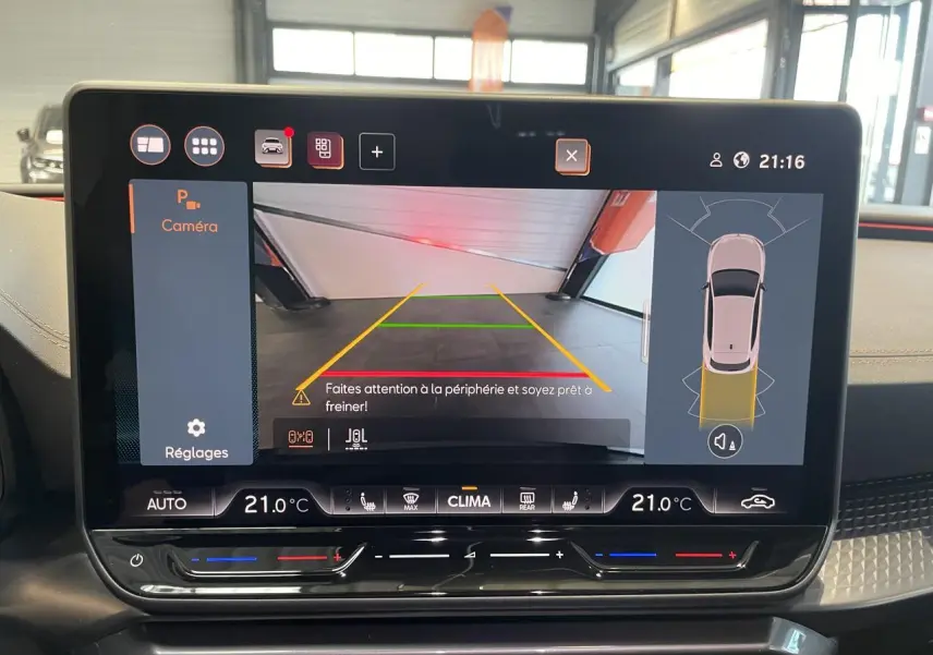 Écran tactile intérieur affichant la caméra de recul et les commandes de climatisation à 21°C sur CUPRA Leon gris Graphène.