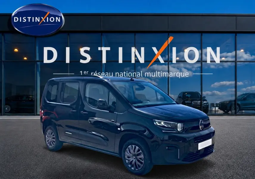 Vue 3/4 avant droit d'un Citroën Berlingo noir avec jantes acier et vitres teintées, devant une vitrine Distinxion.