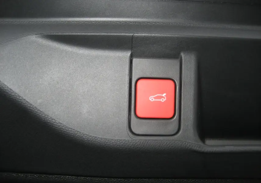 Bouton rouge de déverrouillage du coffre dans l'habitacle du DS4 II Pallas gris platinium 2024.