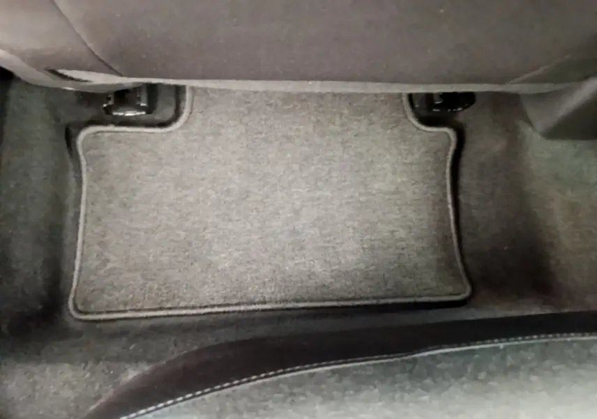 Tapis de sol gris sous le siège avant dans l'habitacle d'une Renault Clio Business blanche 2021.