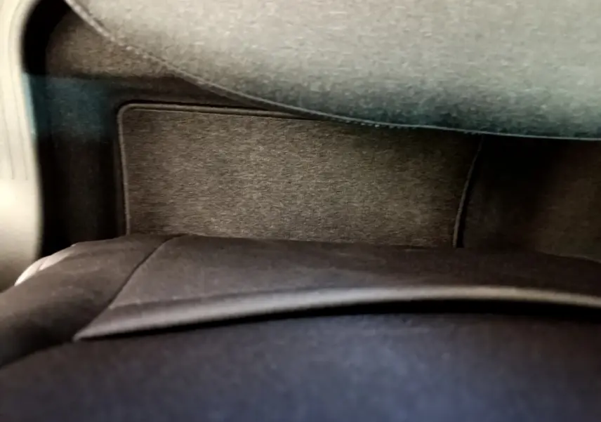Détail de l'intérieur noir du coffre de la Renault Clio Business blanche, vue rapprochée sous tablette arrière.