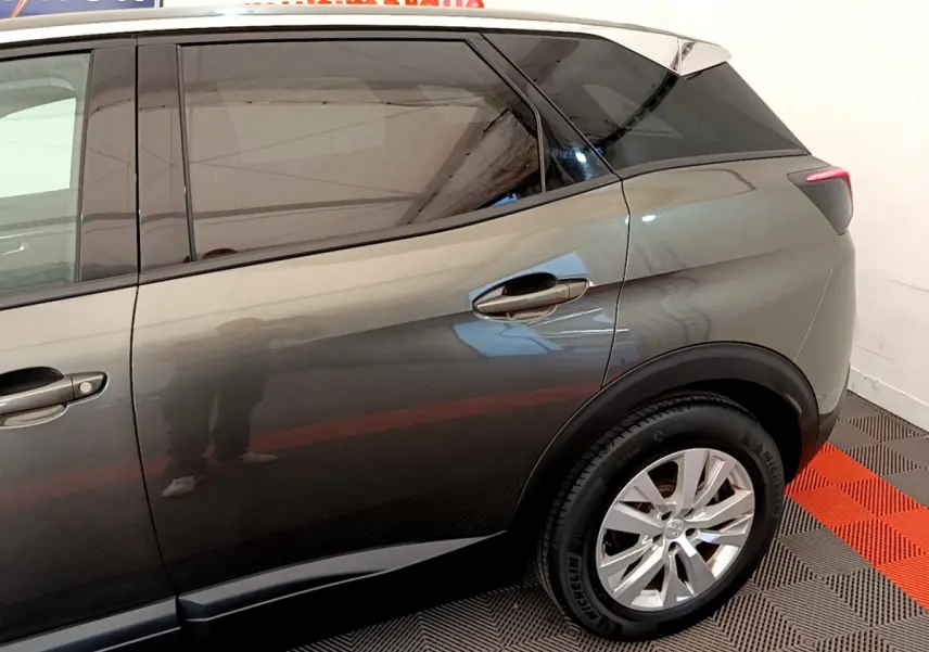 Vue latérale côté droit sur l'arrière d'un Peugeot 3008 gris foncé avec jante alliage et vitres teintées.