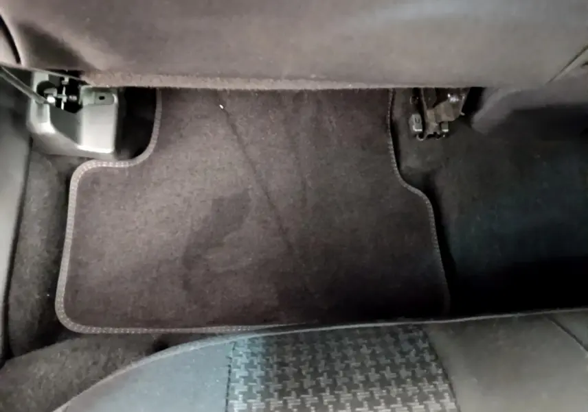 Vue rapprochée du tapis de sol arrière côté droit du Peugeot 3008 gris foncé, avec partie inférieure du siège visible.