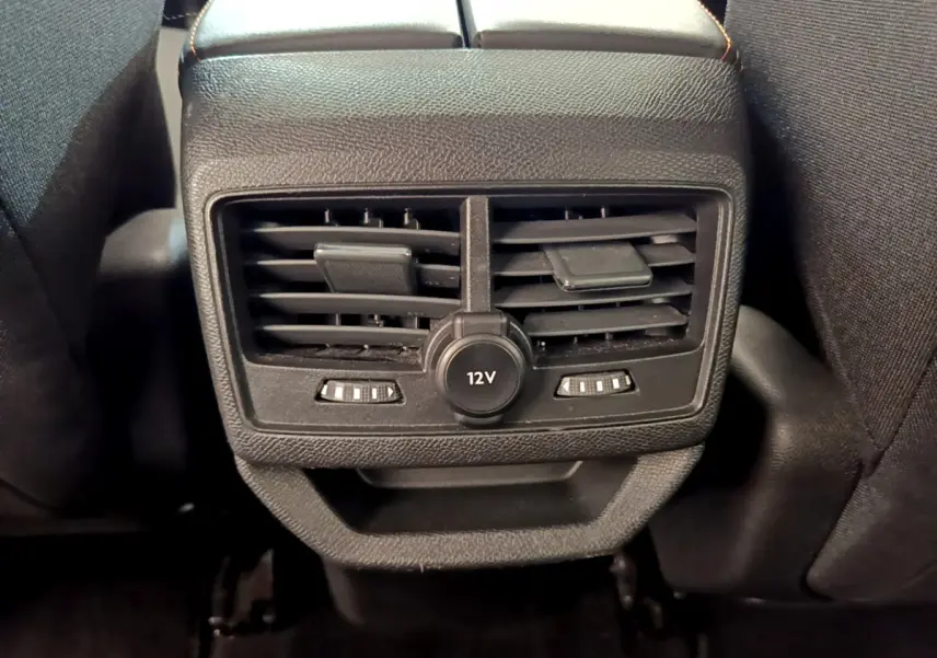Gros plan sur la prise 12V et les aérateurs arrière noirs du Peugeot 3008 gris foncé, vue depuis l'arrière.