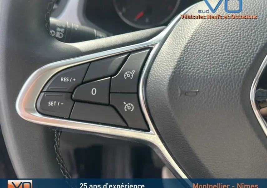 Gros plan sur les commandes du régulateur de vitesse au volant du Renault Captur gris TCe 100 Business 2020