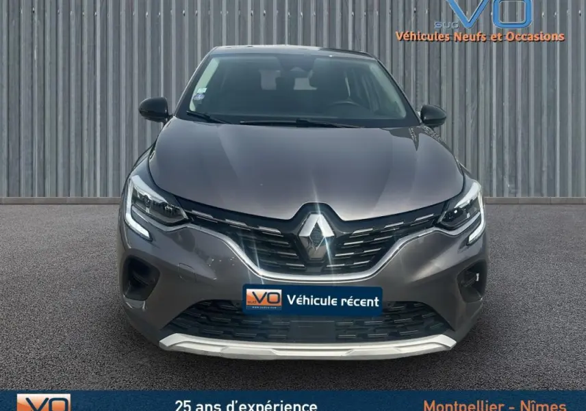 Vue frontale d'un Renault Captur TCe 100 Business gris 2020 avec feux LED allumés et calandre noire brillante.