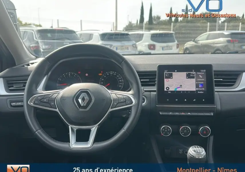 Vue intérieure du tableau de bord du Renault Captur gris 2020 avec volant multifonction et écran tactile central.