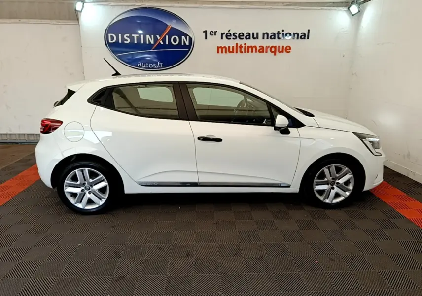 Profil latéral droit d'une Renault Clio Business blanche 2021 dans un showroom avec logo Distinxion en arrière-plan.