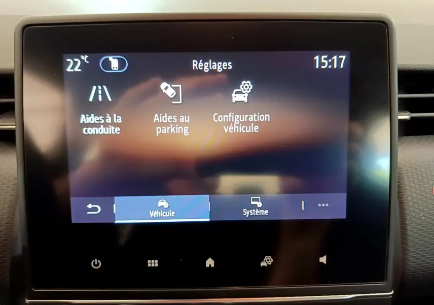Écran tactile central de la Renault Clio Business blanc 2021 affichant les réglages d’aides à la conduite et au parking.