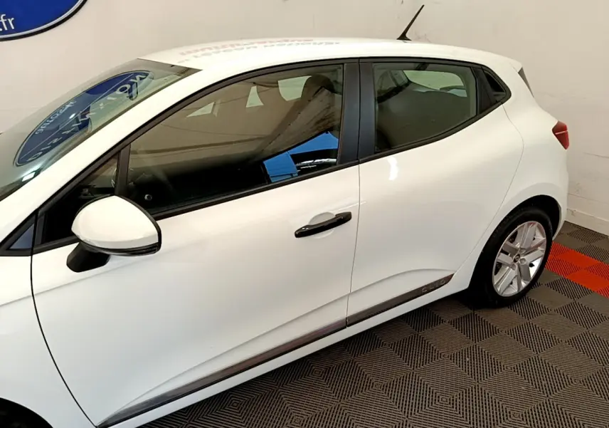 Profil côté gauche d'une Renault Clio Business blanche 2021 avec poignées noires et jantes alliage visibles.