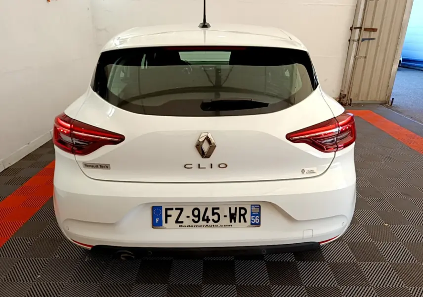 Vue arrière d'une Renault Clio blanche 2021 avec feux LED et plaques d'immatriculation françaises visibles.