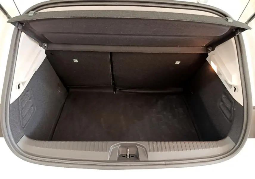 Coffre ouvert vu de l'arrière d'une Renault Clio Business blanche, montrant l'espace de chargement vide et la tablette de séparation.