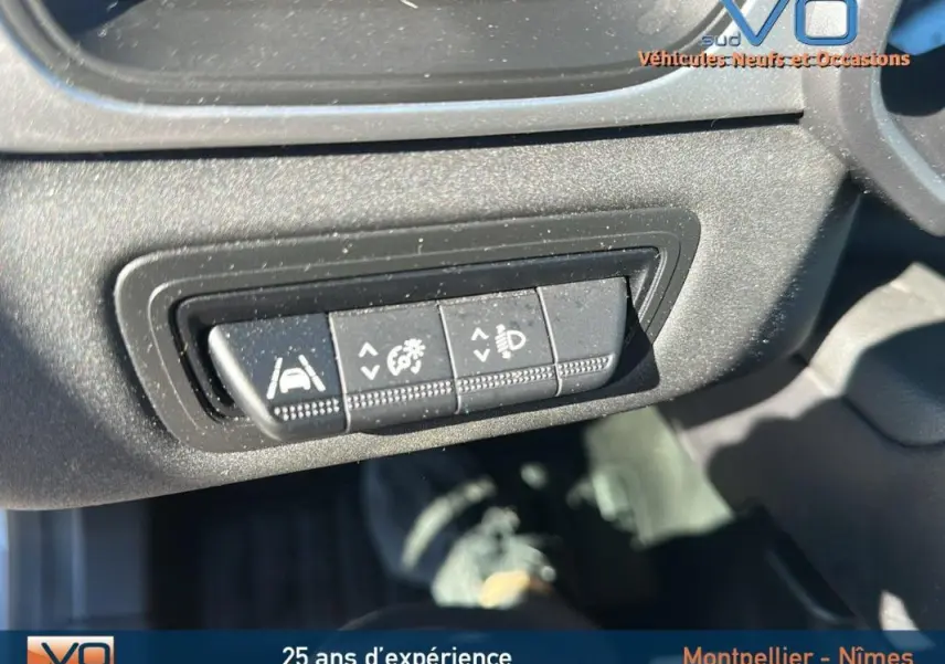 Boutons de réglage des aides à la conduite sur tableau de bord d'un Renault Captur gris essence 2021.