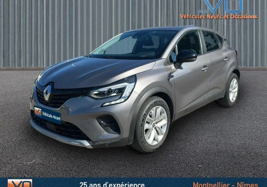 Renault Captur TCe 90 Business gris vu en 3/4 avant droit sur fond neutre avec jantes blanches.