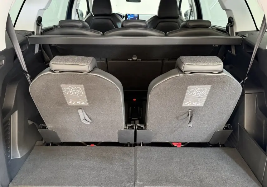 Vue arrière intérieure du coffre du Peugeot 5008 bleu, montrant les sièges arrière individuels rabattus et amovibles.