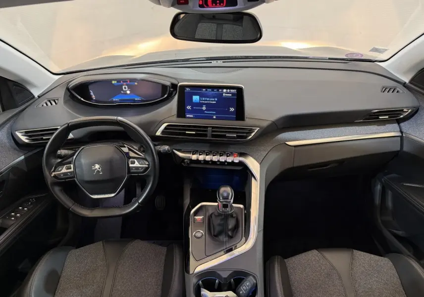 Vue intérieure avant du tableau de bord noir et gris du Peugeot 5008 Puretech 130 avec volant cuir multifonctions et écran tactile central.