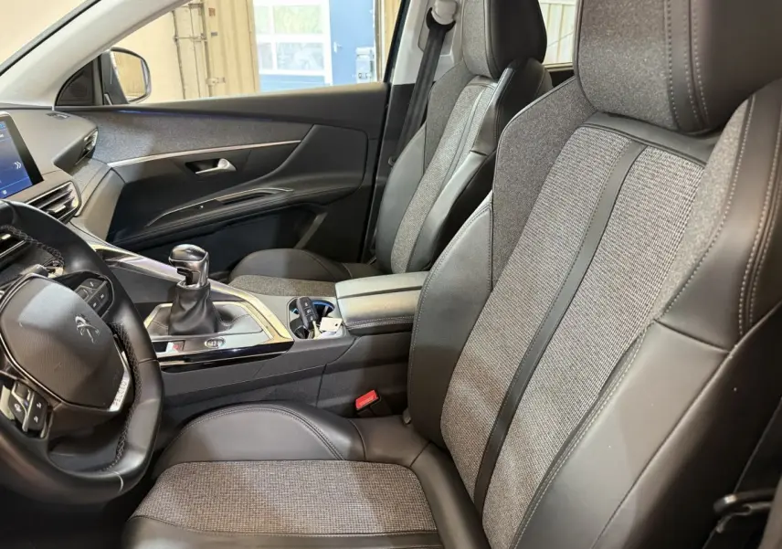 Vue intérieure côté conducteur du Peugeot 5008 Puretech 130 S&S Allure 2019, sièges cuir et tissu gris, volant multifonctions.