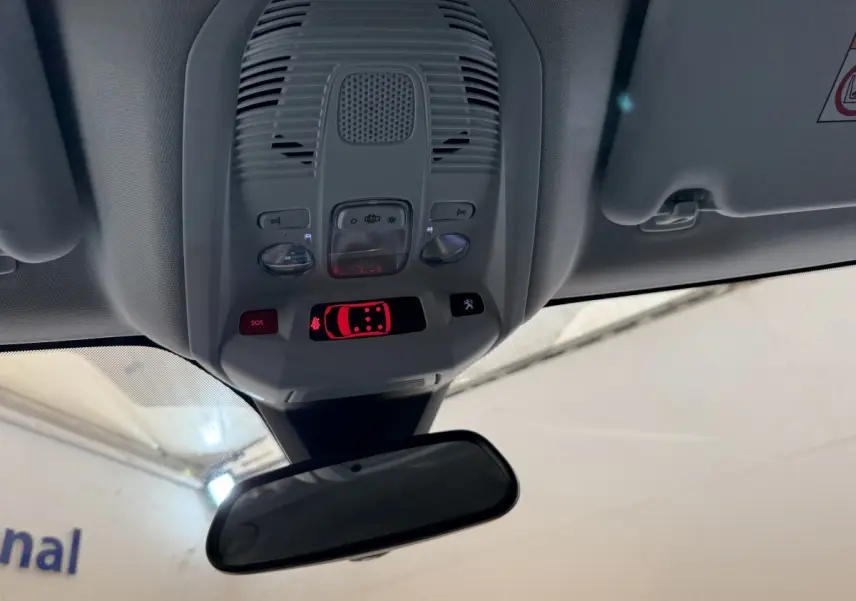 Vue intérieure en plongée du plafonnier gris avec commandes lumineuses et rétroviseur intérieur d’un Peugeot 5008 bleu.