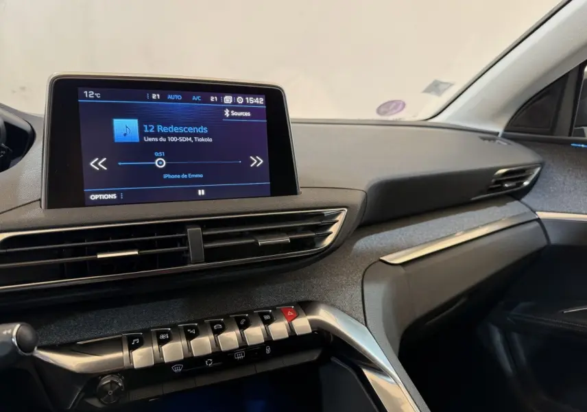Vue intérieure côté passager du tableau de bord du Peugeot 5008 bleu avec écran tactile et commandes piano.