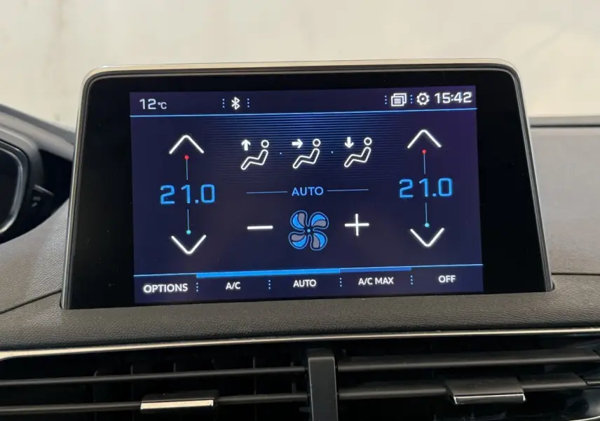 Écran tactile central du tableau de bord du Peugeot 5008 bleu, affichant la climatisation à 21°C en mode automatique.