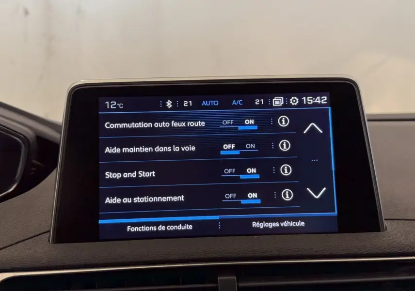 Écran tactile central du Peugeot 5008 bleu, affichant les réglages d’aides à la conduite, vue intérieure frontale.