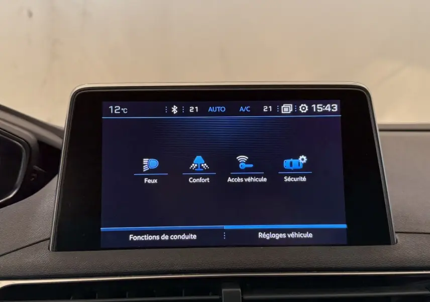 Écran tactile central du Peugeot 5008 bleu, affichant les réglages véhicule en intérieur, vue frontale rapprochée.