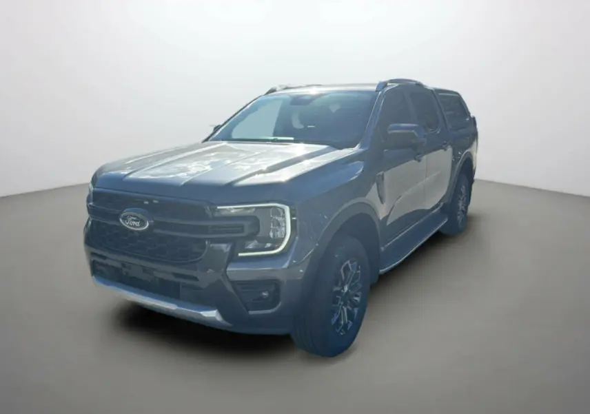 Ford Ranger 3/4 avant droit gris carbone avec hard-top vitré et jantes alu 18 pouces sur fond neutre.