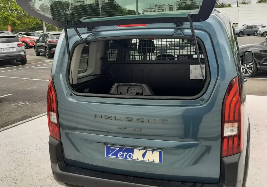 Vue arrière d'un Peugeot Rifter bleu Kiama 2026 avec hayon ouvert montrant l'espace de chargement vide.