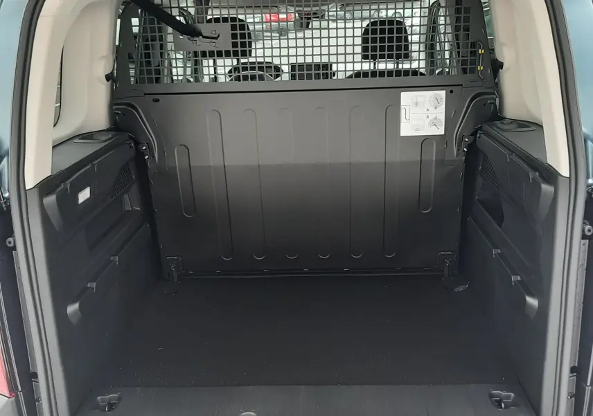 Vue arrière du Peugeot Rifter bleu Kiama montrant l'espace de chargement avec cloison de séparation métallique.