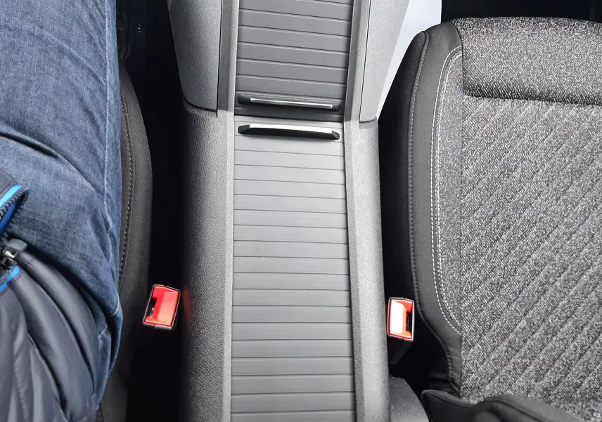 Vue plongeante sur la console centrale noire et les sièges gris tissu du Peugeot Rifter 2026, version BlueHDi diesel.