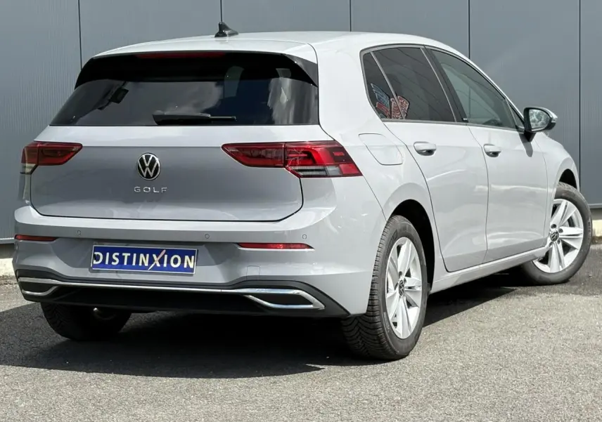 Vue 3/4 arrière droite d'une Volkswagen Golf VIII gris lunaire avec feux arrière LED et jantes alliage 16 pouces.
