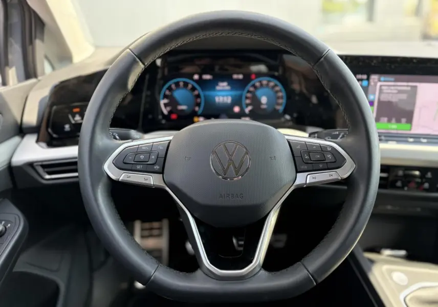 Volant cuir multifonction de Volkswagen Golf VIII 1.5 TSI 2024 avec tableau de bord digital et écran tactile visible.