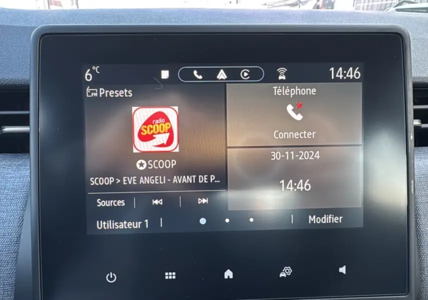 Écran tactile central de la Renault Clio 2025 gris schiste affichant la radio et la connexion téléphone.