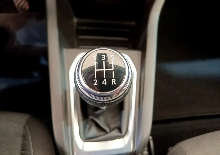 Gros plan sur le levier de vitesses manuel noir de la Renault Clio Business blanche, avec console centrale grise visible.