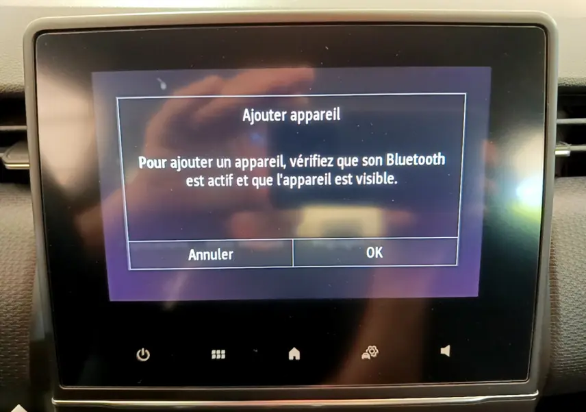 Écran tactile central de la Renault Clio Business blanc 2021 affichant la demande d'ajout d'appareil Bluetooth.