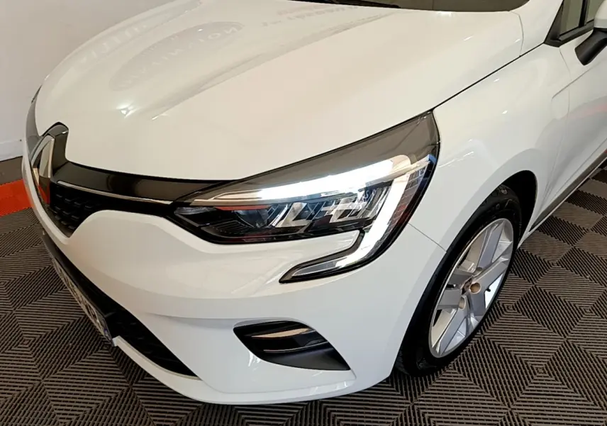 Vue 3/4 avant droit d'une Renault Clio Business blanche mettant en valeur ses phares LED et jantes alliage.