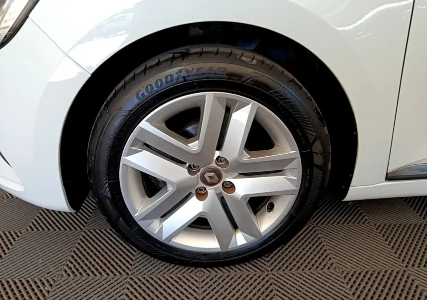 Gros plan sur la roue avant gauche de la Renault Clio Business blanche, mettant en valeur la jante alliage et le pneu Goodyear.