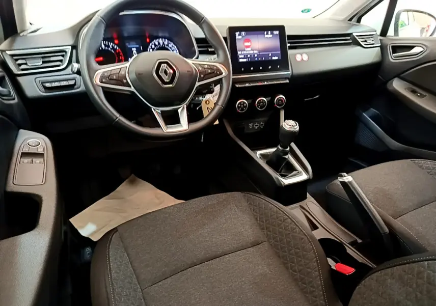 Intérieur Renault Clio Business 2021 vu côté conducteur, volant cuir, écran tactile et levier de vitesse manuel visibles.