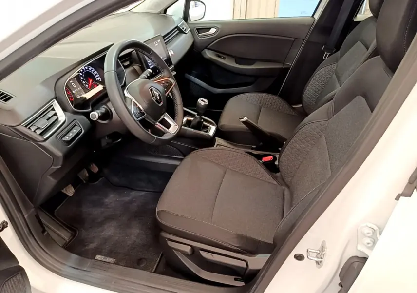 Vue intérieure côté conducteur de la Renault Clio Business blanche, avec tableau de bord moderne et sièges tissu gris.