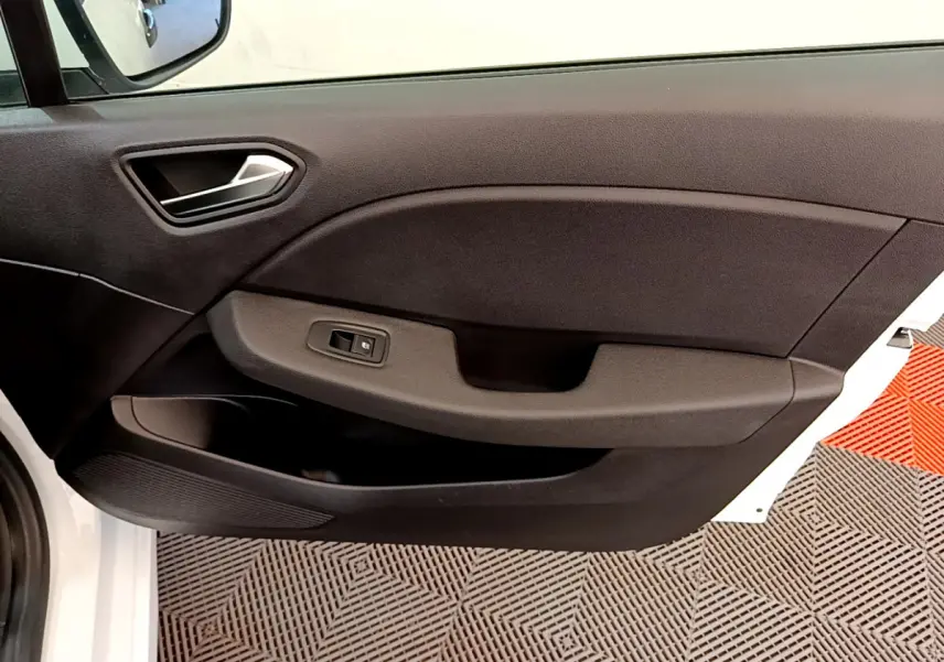 Vue rapprochée de la porte avant gauche noire d'une Renault Clio Business blanche, avec poignée et commande de vitre.