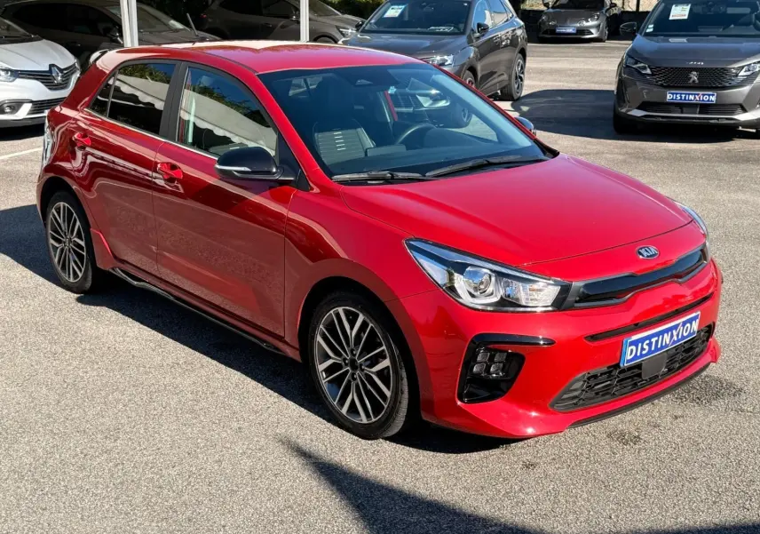KIA RIO 2022 rouge grenadine vue 3/4 avant droit, avec jantes alliage et calandre noire GT-Line distincte.